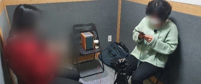 부스 안에서 휴대전화로 통화 상황을 재현해 녹음하는 참여자